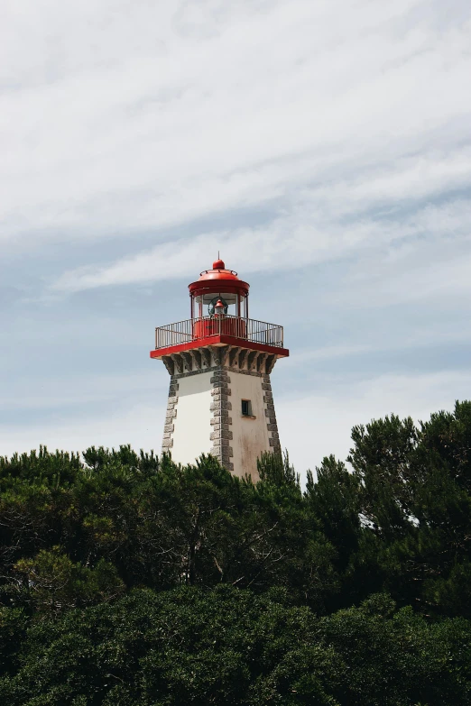 a red and white lighthouse surrounded by trees, les nabis, granville chandor, overlooking the ocean, square, high-quality photo