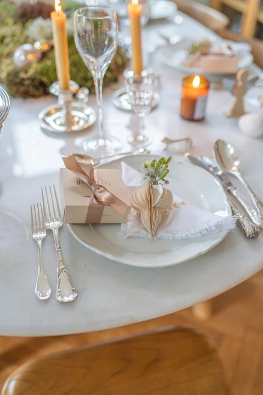 a white table topped with plates and silverware, sitting at table