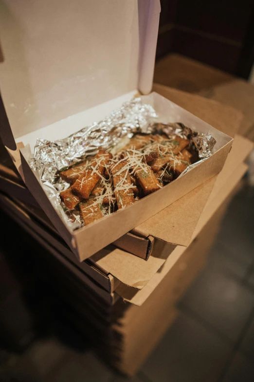 a box of food sitting on top of a table, scrolls, exterior shot, cheesy, various sizes