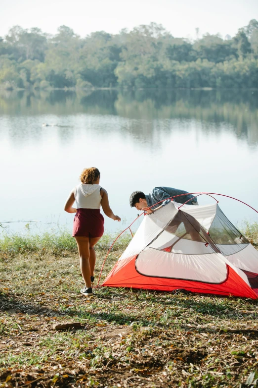 a couple of people standing next to a tent, on a lake, explore, on a riverbank, gen z