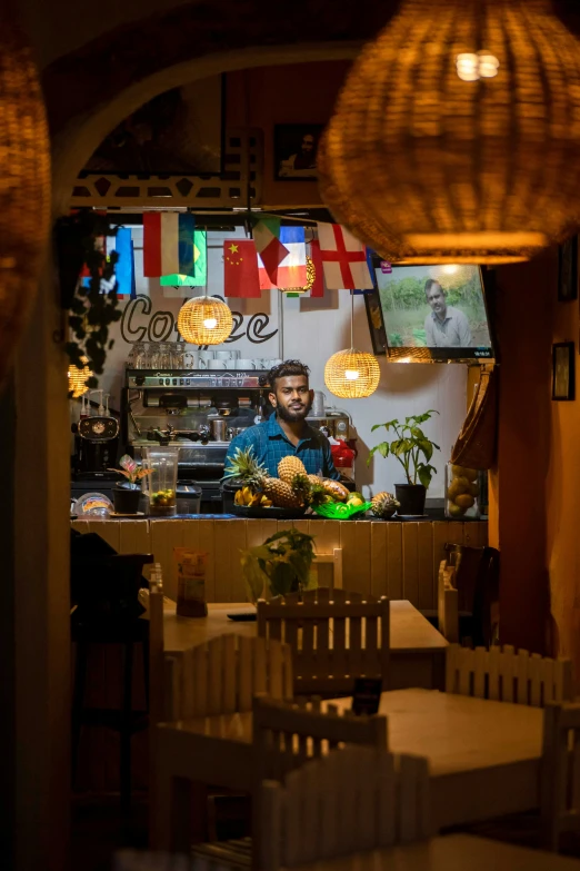 a person sitting at a table in a restaurant, enes dirig, cosy atmosphere, at the world cup, lights inside