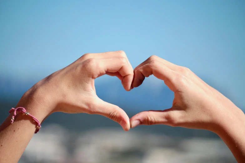 a person making a heart with their hands, by Niko Henrichon, pexels, 🚿🗝📝, profile image, holding each other, advertising photo