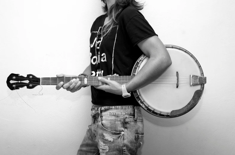 a black and white photo of a man holding a banjo, an album cover, by Fede Galizia, tumblr, antipodeans, jeans and t shirt, female gigachad, tuning, rosalia