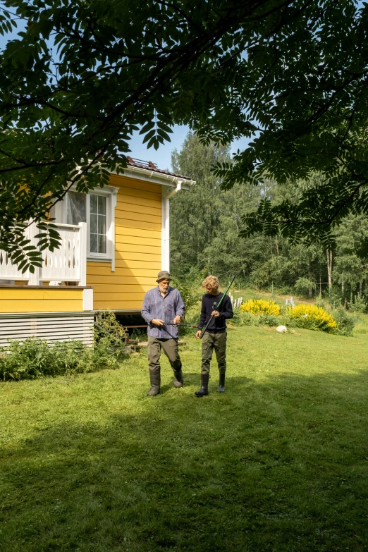 a couple of men standing on top of a lush green field, a picture, by Eero Järnefelt, standing outside a house, yellow and green scheme, permaculture, touring