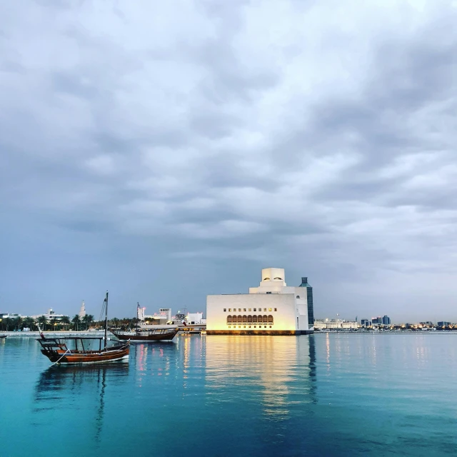 a group of boats floating on top of a body of water, pexels contest winner, hurufiyya, white building, ameera al taweel, museum setting, calm evening