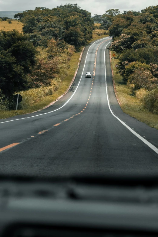 a car driving down the middle of a road, in the distance, curves, thumbnail, touring