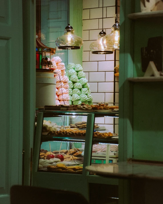 a bakery filled with lots of pastries and pastries, by Elsa Bleda, trending on unsplash, art nouveau, simple detail. greenish lighting, facing away, macaron, profile image