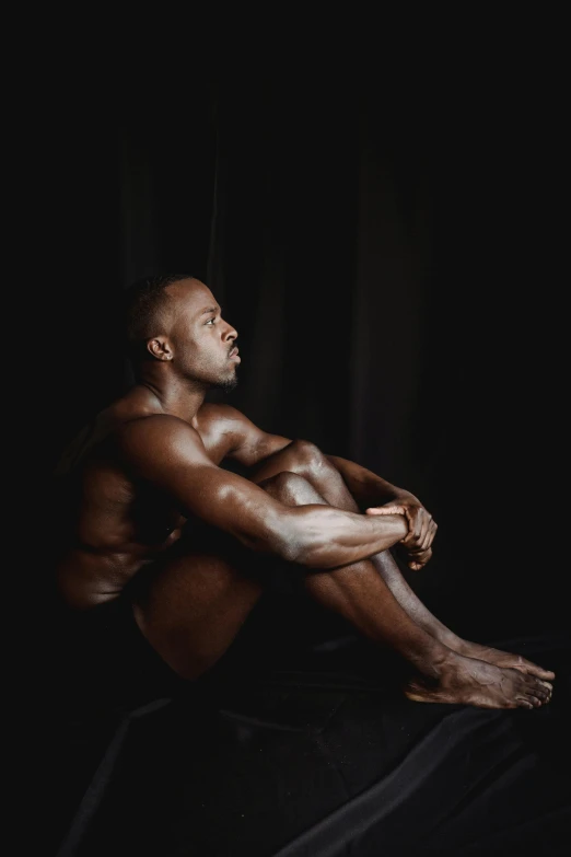 a man sitting on a bed in the dark, a portrait, by Jessie Alexandra Dick, pexels contest winner, hyperrealism, body builder, fully chocolate, profile pic, black body