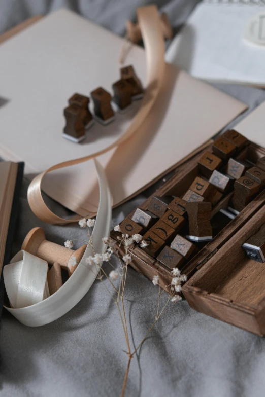 an open suitcase sitting on top of a bed, a still life, inspired by Louise Nevelson, unsplash, letterism, chocolate art, ribbons, medium close up shot, rubber stamp