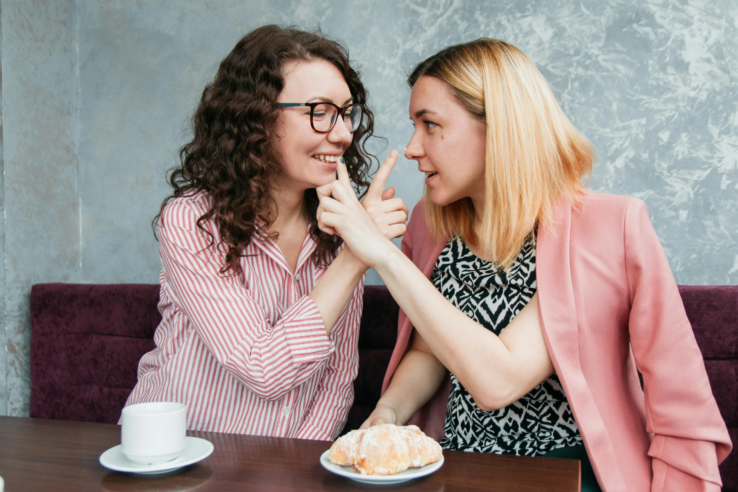 two women sitting at a table having a conversation, a portrait, by Julia Pishtar, shutterstock, antipodeans, kiss mouth to mouth, one blonde and one brunette, with pointing finger, coffee smell