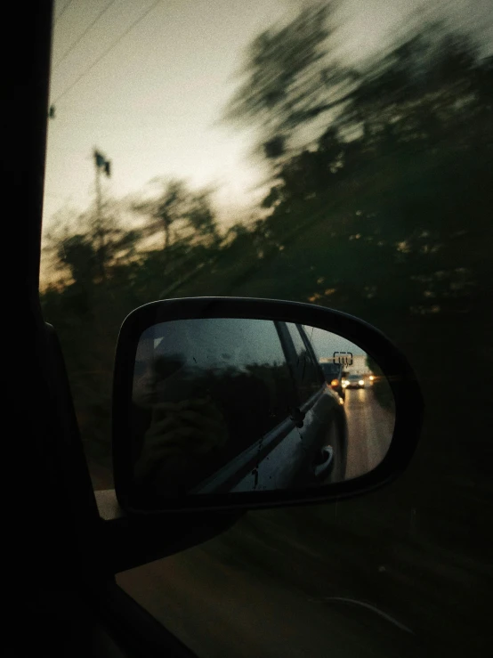 a rear view mirror on the side of a car, inspired by Nan Goldin, unsplash contest winner, humid evening, low quality photo, instagram story, eyelevel!!! view!!! photography