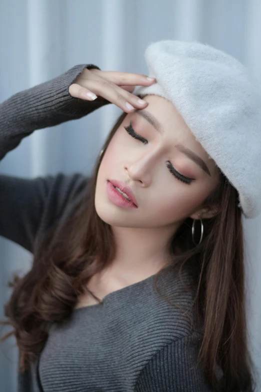 a woman wearing a gray sweater and a white hat, a cartoon, trending on pexels, beautiful asian girl, sleepy fashion model face, malaysian, makeup