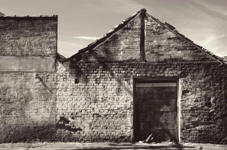 a black and white photo of an old building, a black and white photo, pexels contest winner, in front of a garage, crumbling masonry, medium format. soft light, old sepia photography