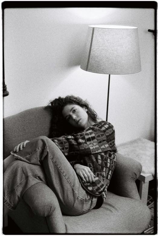 a black and white photo of a man sitting on a couch, a black and white photo, by Larry Fink, renaissance, woman looks like gilda radner, portrait of depressed teen, instagram picture, curly haired