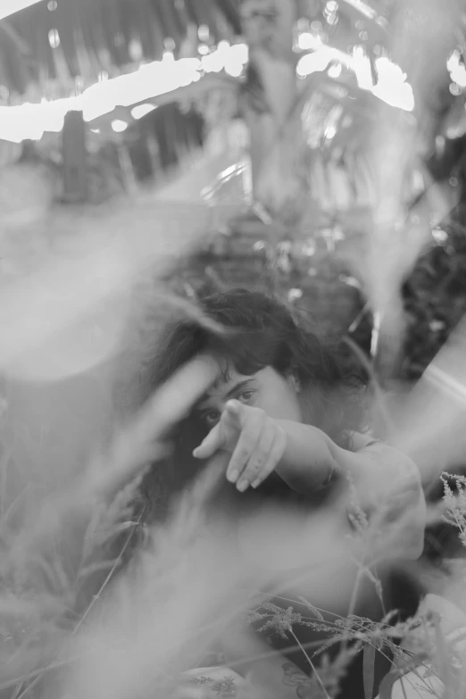 a black and white photo of a bride and groom, inspired by Sergio Larraín, tumblr, conceptual art, laying down in the grass, hands shielding face, multiexposure, in a jungle