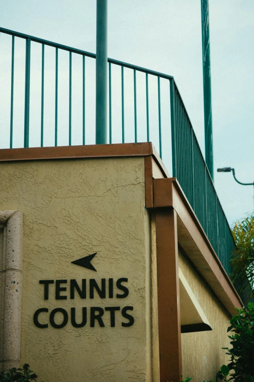 a tennis court sign on the side of a building, by Robbie Trevino, trending on unsplash, rex orange county, instagram story, tourist photo, adjacent hallways