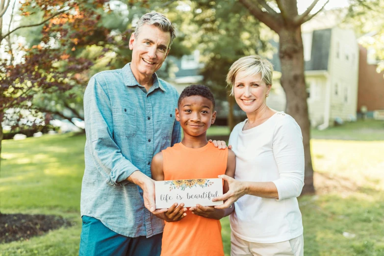 a man standing next to a woman and a boy, a picture, pexels contest winner, folk art, woman holding sign, product introduction photo, holding gift, diverse