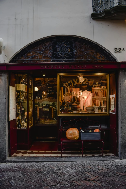 a store front on a cobblestone street, by Daniel Seghers, pexels contest winner, art nouveau, burnt sienna and venetian red, interior of a small, religious, crafts and souvenirs