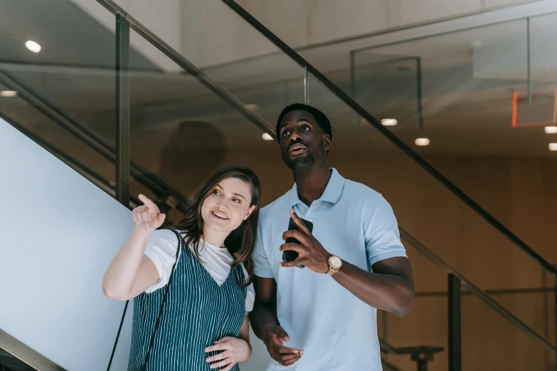 a man and a woman standing next to each other, a picture, by Carey Morris, pexels contest winner, pointing, mkbhd, charli bowater and artgeem, high quality upload