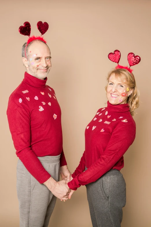 a man and a woman standing next to each other, a photo, inspired by Peter de Seve, antipodeans, wearing festive clothing, falling hearts, wearing turtleneck, ( ( photograph ) )