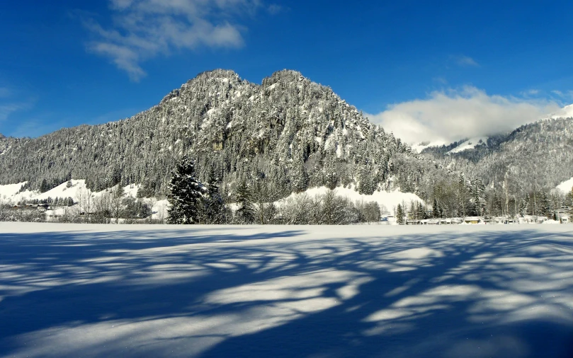 a snow covered field with a mountain in the background, pexels contest winner, baroque, evergreen valley, thumbnail, multiple wide angles, clear blue skies