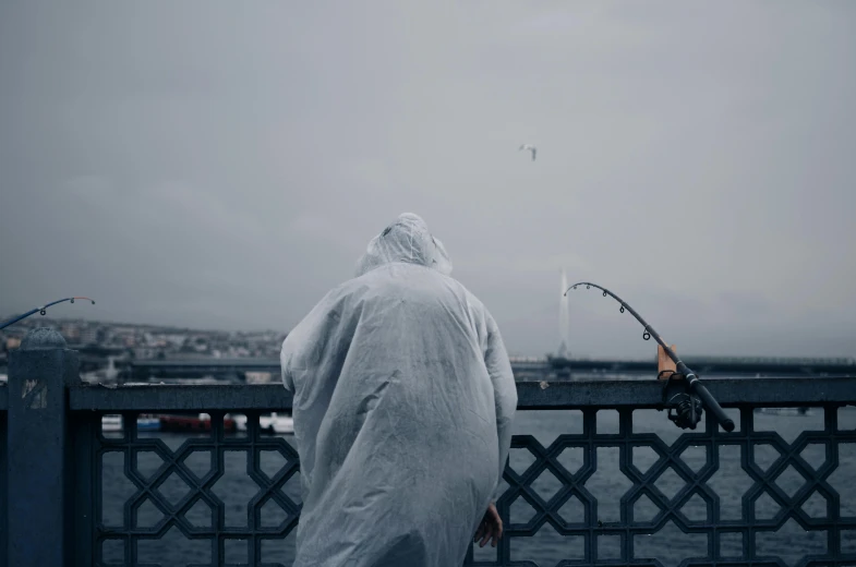 a person standing on a bridge with a fishing rod, a statue, pexels contest winner, hyperrealism, grey robe, a sharknado, istanbul, wearing white silk hood