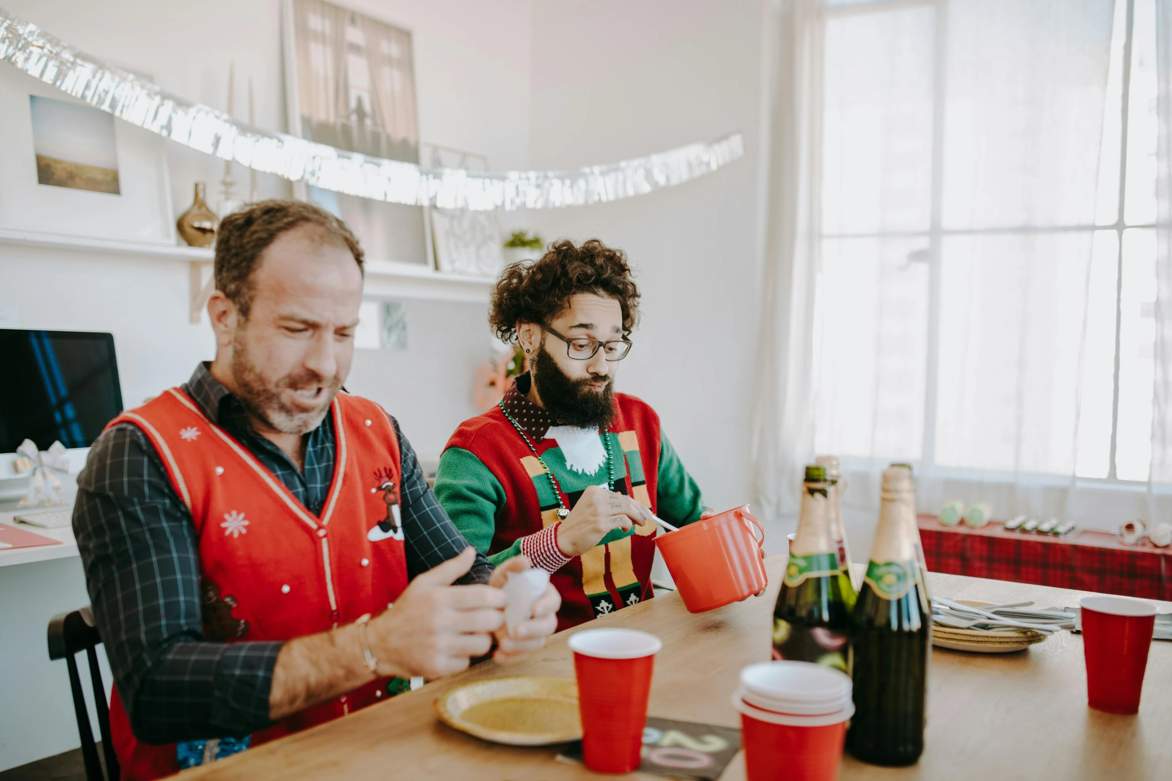 a couple of people that are sitting at a table, pexels contest winner, santa's workshop, awkwardly holding red solo cup, hipster dad, gif