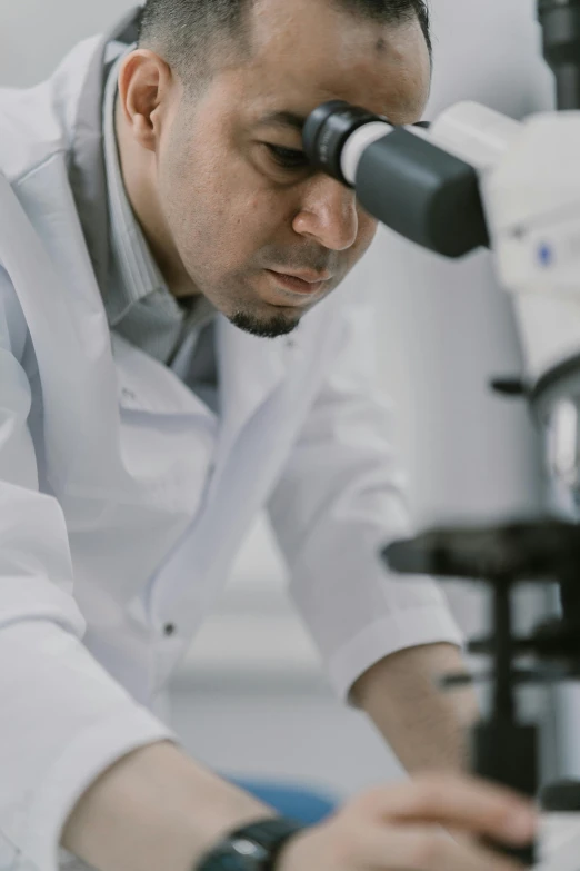 a man in a lab coat looking through a microscope, pexels contest winner, reza afshar, instagram story, profile image, worried