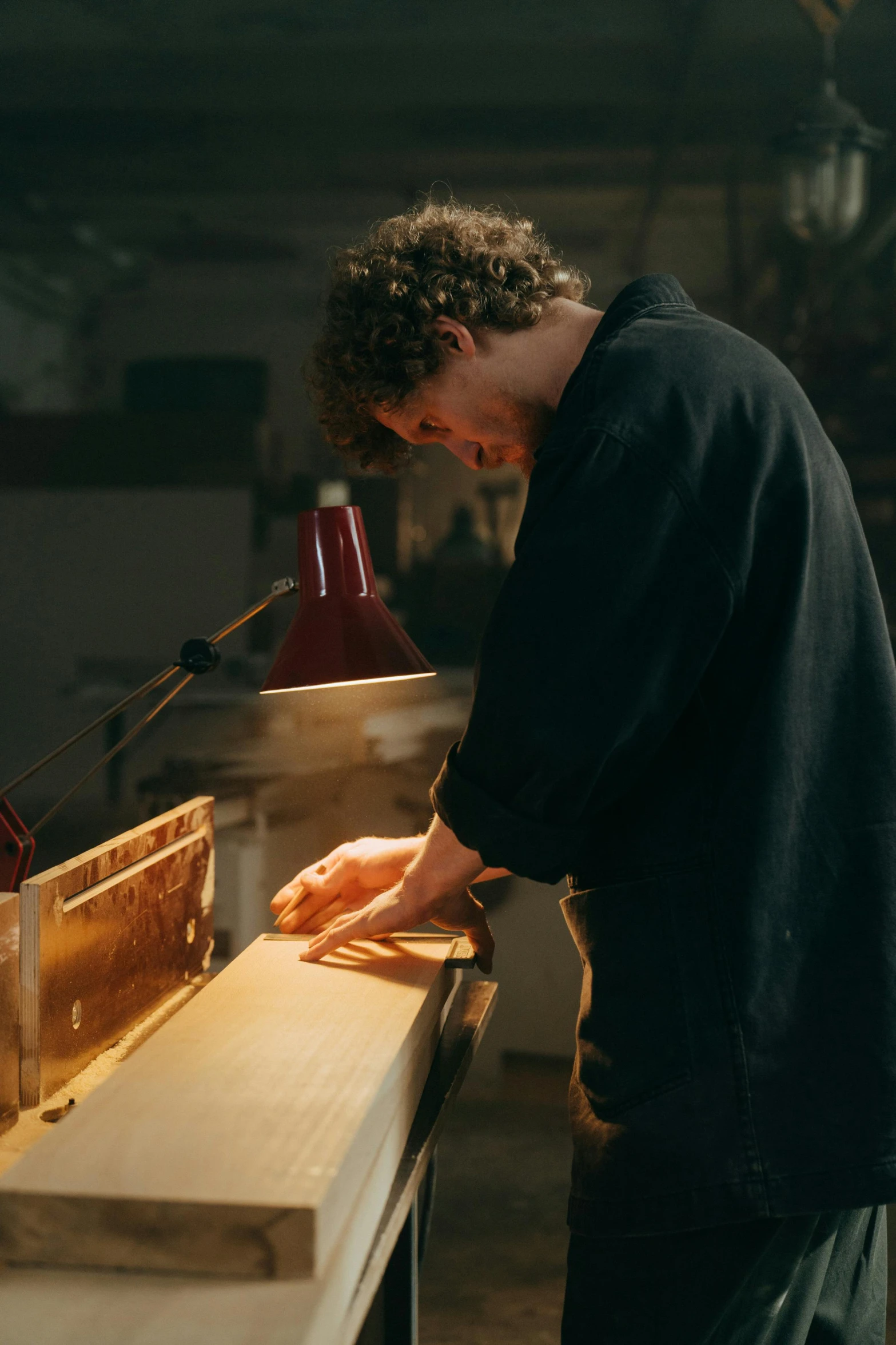 a man working on a piece of wood, by Jacob Toorenvliet, trending on unsplash, arbeitsrat für kunst, made of glowing wax and ceramic, perfectly lit. movie still, gilding, aussie