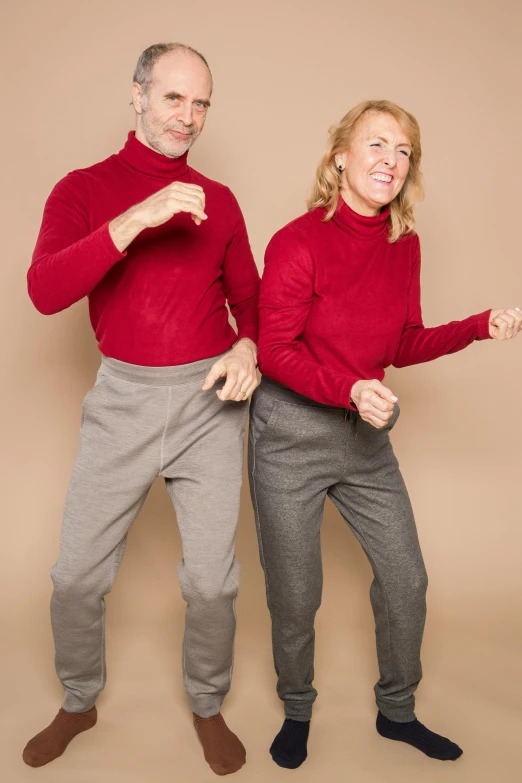 a man and a woman standing next to each other, inspired by Graham Forsythe, antipodeans, red sweater and gray pants, playful pose, wearing correct era clothes, brown pants