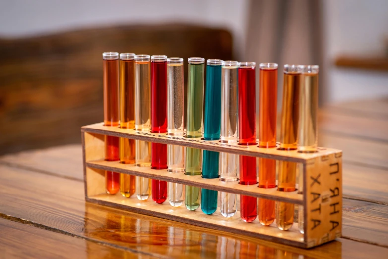 a row of test tubes sitting on top of a wooden table, inspired by Évariste Vital Luminais, vibrant hues, on a wooden tray, scientific glassware, industrial colours