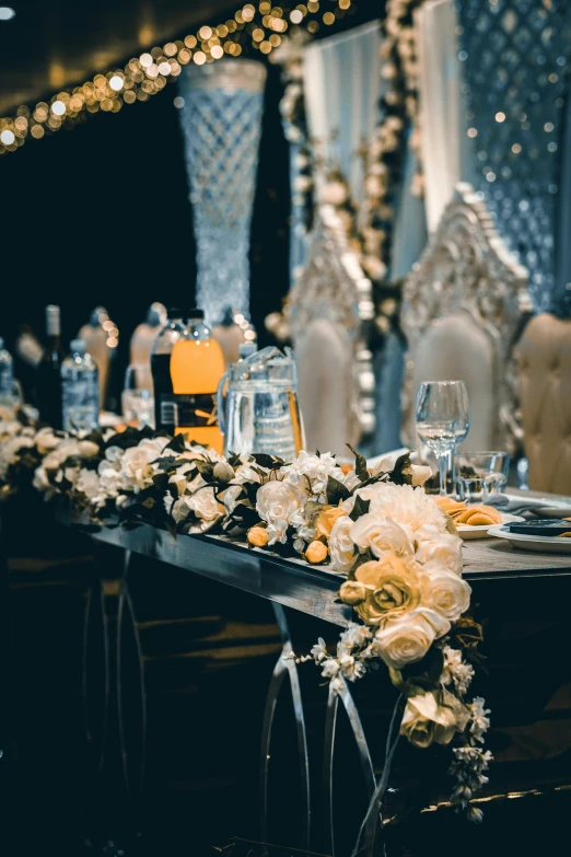 a table that has a bunch of flowers on it, unsplash, baroque, silver and yellow color scheme, multiple stories, upscale photo, evening