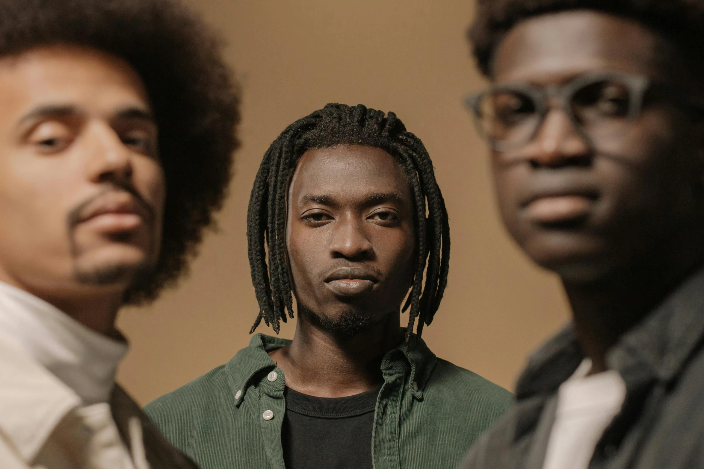 a group of men standing next to each other, an album cover, by Nyuju Stumpy Brown, pexels contest winner, afrofuturism, close up portrait shot, calm expression, three quarter portrait, band promo