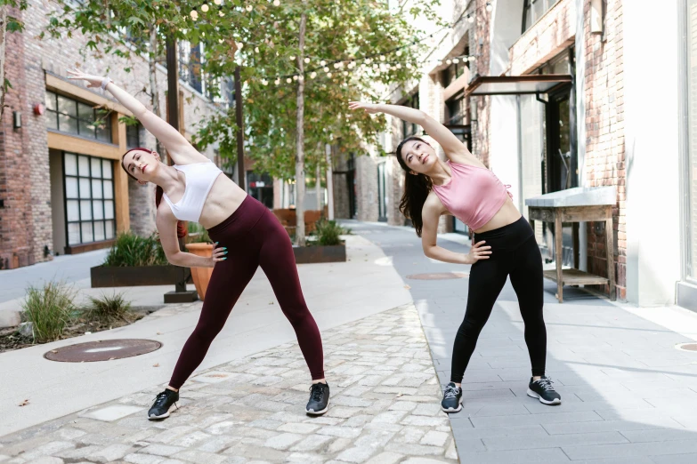 a couple of women standing next to each other on a sidewalk, arabesque, dynamic stretching, charli bowater and artgeem, zig zag, bulky build