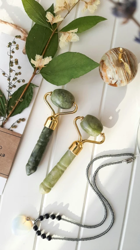 a bunch of jewelry sitting on top of a table, green and gold, healing tubes, professional product photo, scepter
