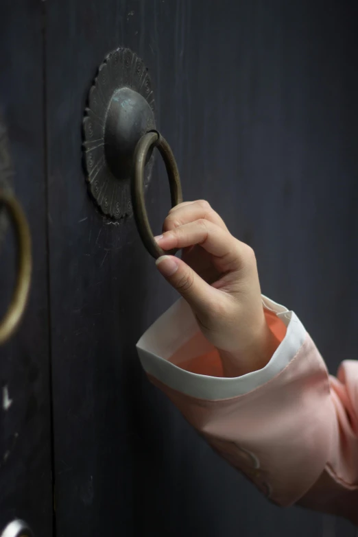 a close up of a person opening a door, inspired by Li Di, photographed for reuters, looking at the treasure box, lulu chen, handcuffed