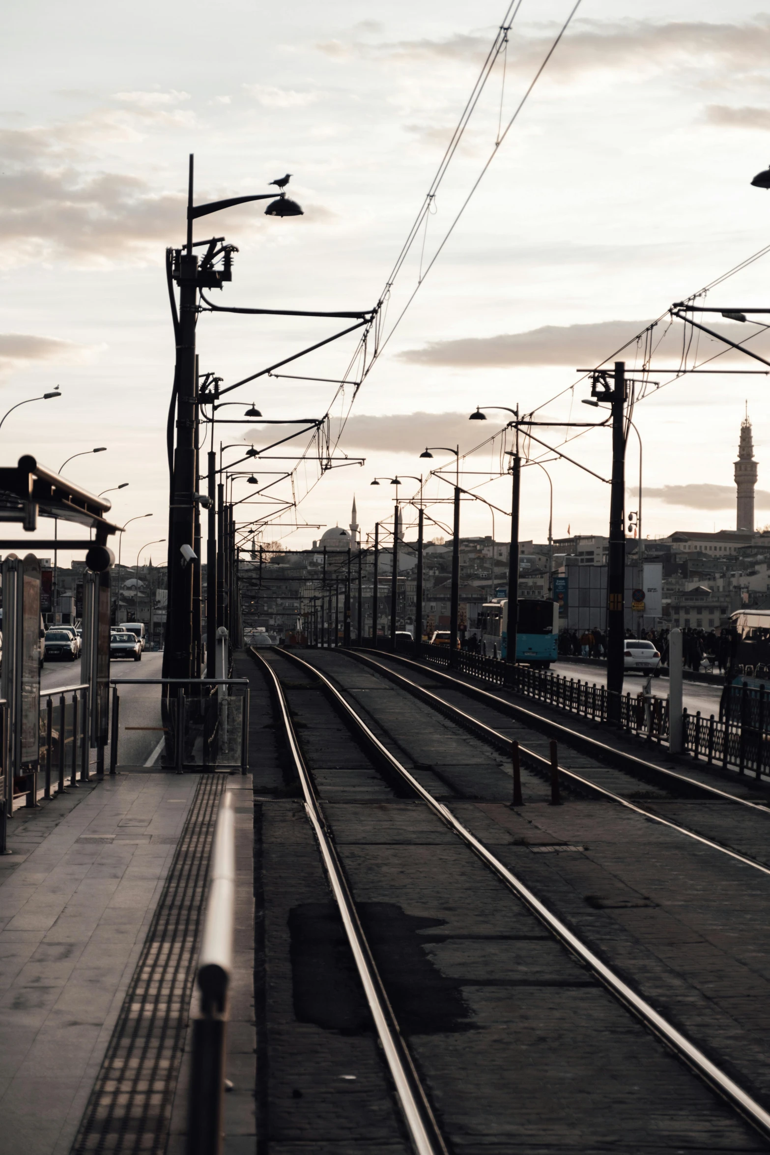 a train traveling down train tracks next to a train station, a picture, by irakli nadar, unsplash, damascus, sky line, square, grayish