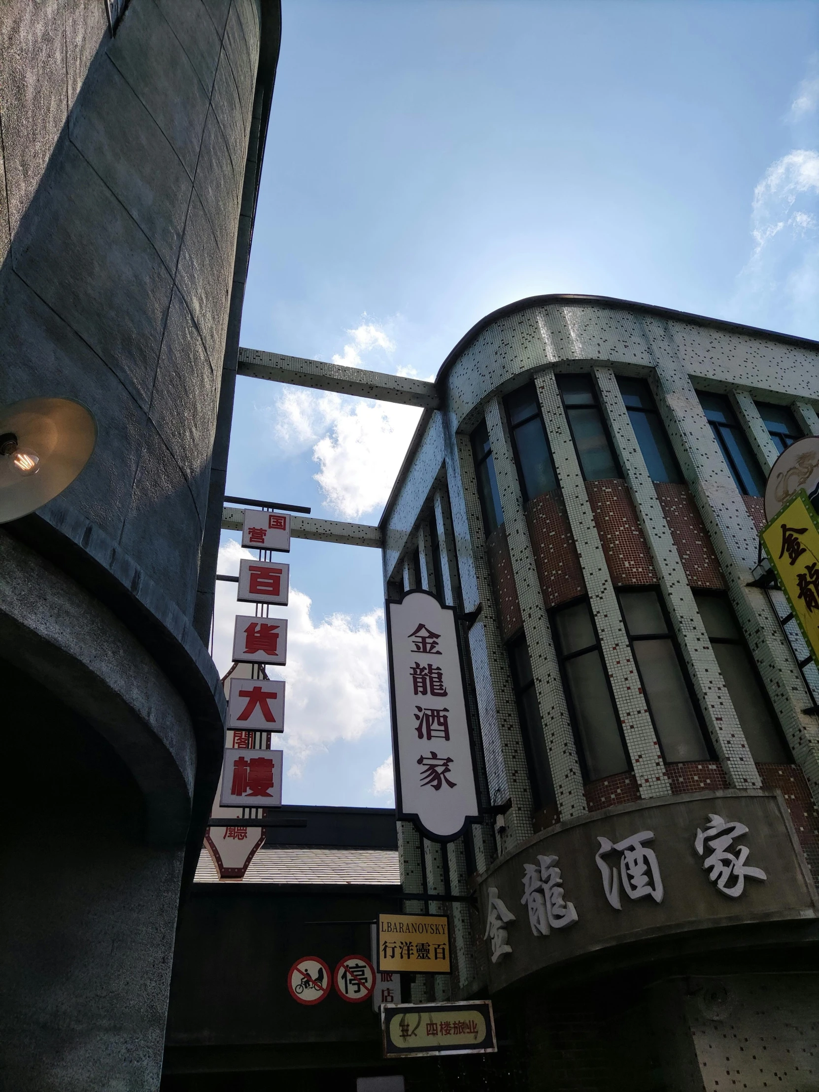 a couple of tall buildings sitting next to each other, an album cover, mingei, old signs, low angle photo, chinese architecture, restaurant!