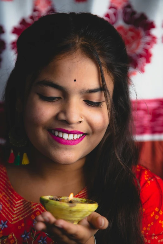 a close up of a person holding a bowl of food, pexels contest winner, beautiful young himalayan woman, neon yellow madhubani, square, eating cakes