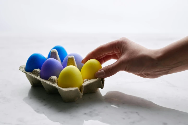 a person reaching for colored eggs in a carton, inspired by Jeff Koons, unsplash, 3 d print, angled shot, in colour, eastern european origin