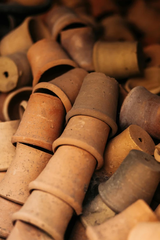 a pile of clay pots sitting on top of a table, brown holes, recycled, up close, corsets