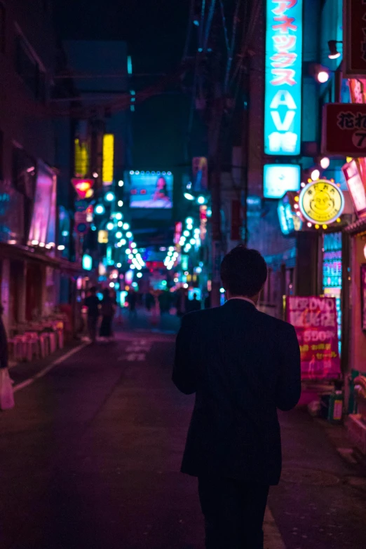 a man walking down a street at night, inspired by Liam Wong, pexels contest winner, neo-figurative, pink yellow and blue neon signs, japanese downtown, ( ( theatrical ) ), japanese city