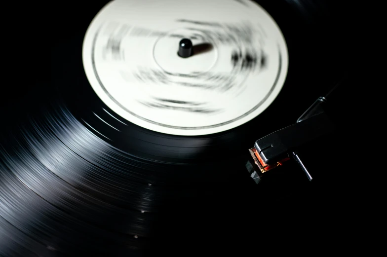 a close up of a vinyl record on a table, an album cover, by Doug Ohlson, unsplash, private press, spinning, (night), an instrument, white noise