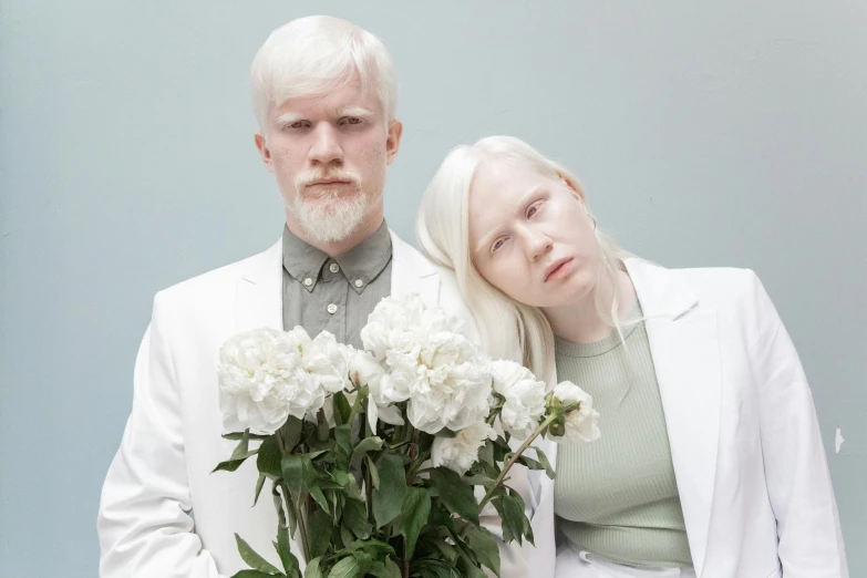 a man and a woman standing next to each other, an album cover, by Matija Jama, albino white pale skin, white flowers, short white beard, photo from a promo shoot