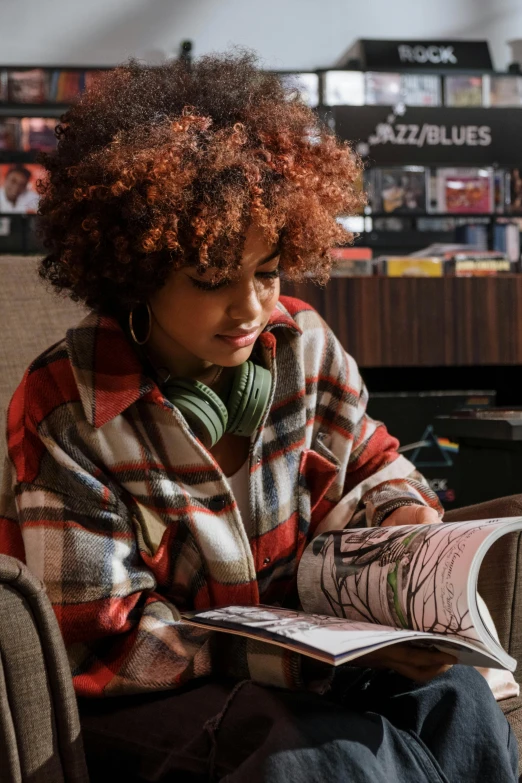 a woman sitting in a chair reading a book, a digital rendering, trending on pexels, happening, girl in a record store, curly afro, aged 13, magazines