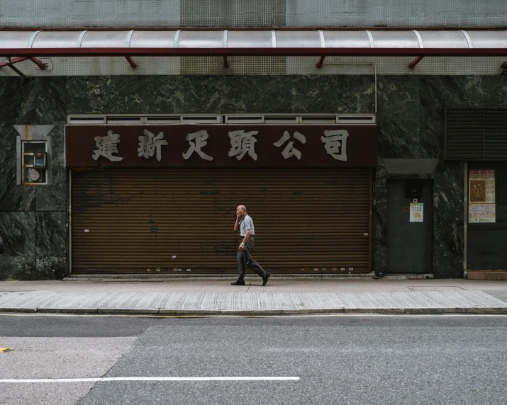 a man walking down the street in front of a building, by Will Ellis, pexels contest winner, shin hanga, chinese text, shuttered mall store, an abandoned old, lee madgwick & liam wong