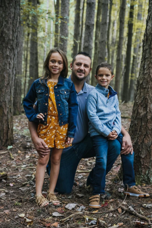 a family poses for a picture in the woods, a portrait, by Chris Rallis, pexels contest winner, plain background, boy, portrait of family of three, joel torres