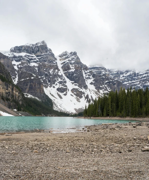 a large body of water with mountains in the background, by Brigette Barrager, pexels contest winner, hurufiyya, banff national park, rocky terrain, only snow in the background, multiple stories