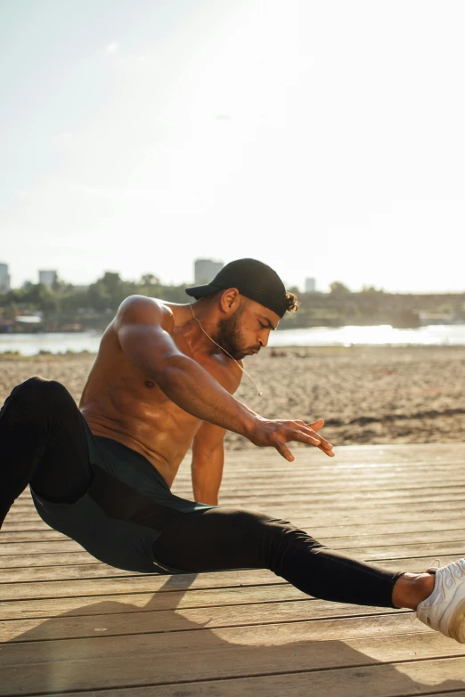 a man doing stretching exercises on a boardwalk, an album cover, pexels contest winner, bodybuilder ernest khalimov, scorpion tail, gal yosef, battle action pose