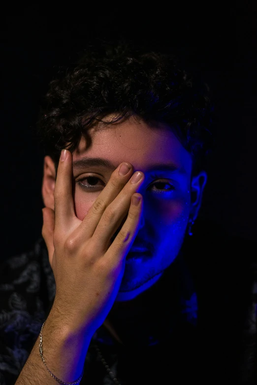 a close up of a person holding their hands to their face, an album cover, pexels contest winner, mannerism, ari aster, bisexual lighting, casual pose, black light